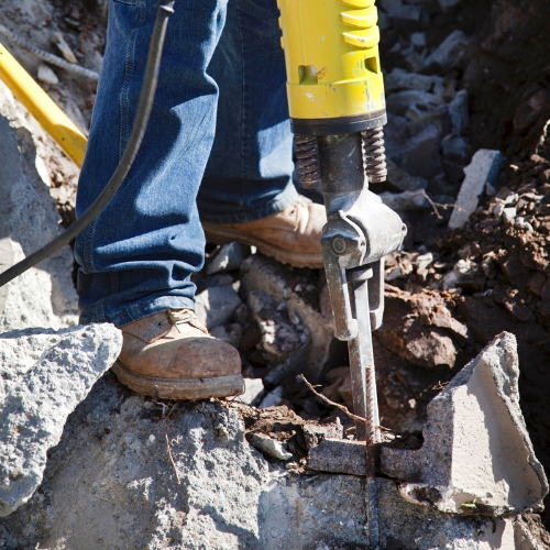 A yellow jack hammer being used